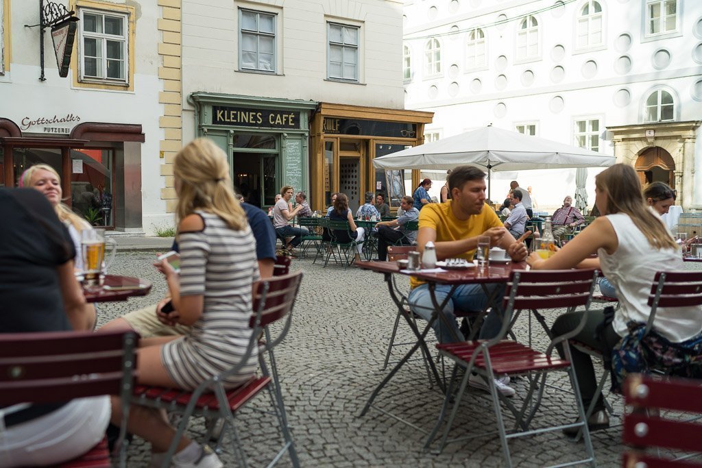 People sitting at Kleines Café at Franziskanerplatz in Vienna 