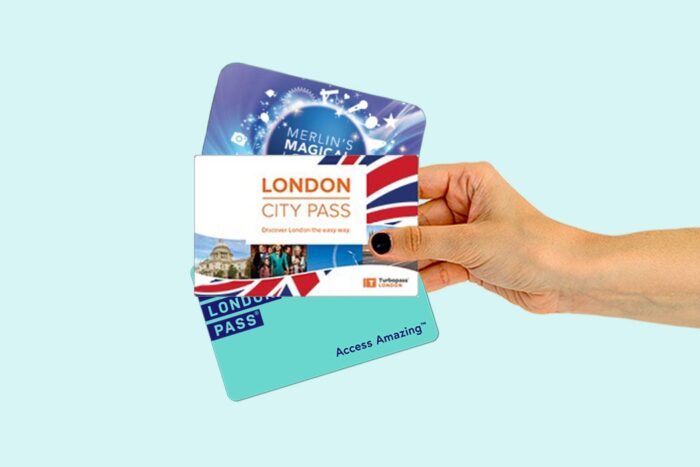 Hand holding a selection of London city passes.